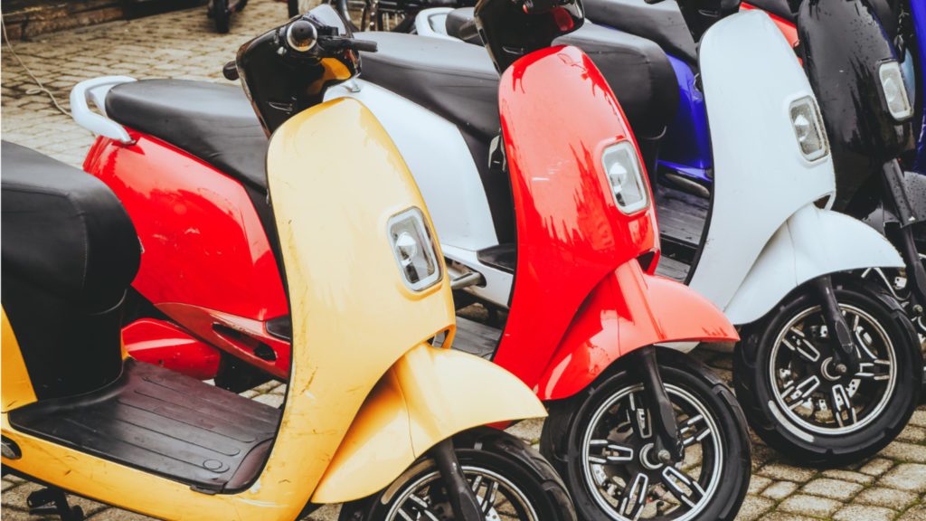 colorful two-wheelers parked on sidewalk