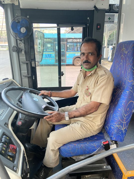 bus driver in driver's seat of an electric bus in Navi Mumbai