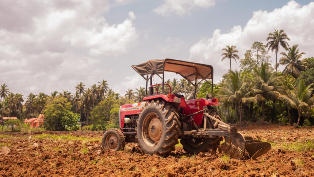 red agricultural tractor on a field in Goa, India