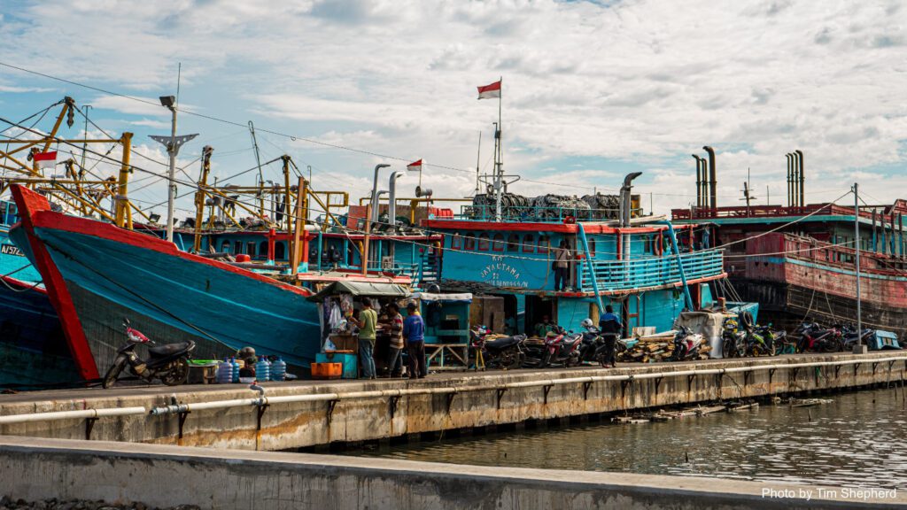 Fishing boat docked in Jakarta, Indonesia, with the flag of Indonesia flying at the top